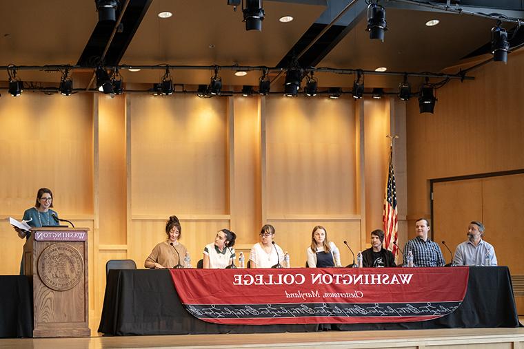 Students appear on stage during the Presidential Symposium during the first panel on artificial intelligence.